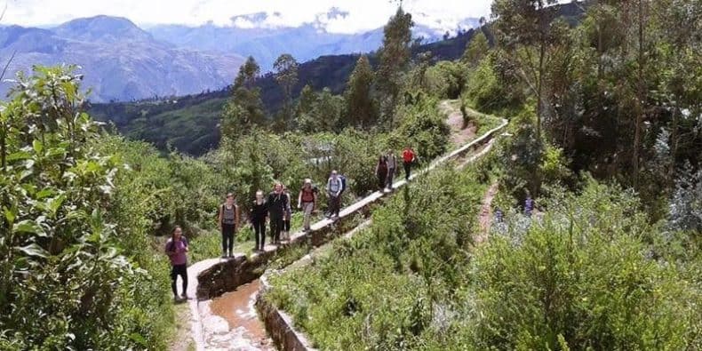 Salkantay trekkers walking along a section of an Inca aqueduct