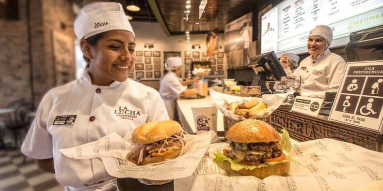 Trabajadora de La Lucha Sangucheria, sirviendo sandwiches tradicionales