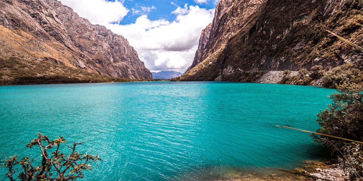 laguna de azul cristalino con montañas - cosas por hacer en perú