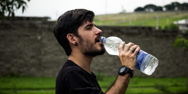 joven tomando agua para prevenir el mal de altura